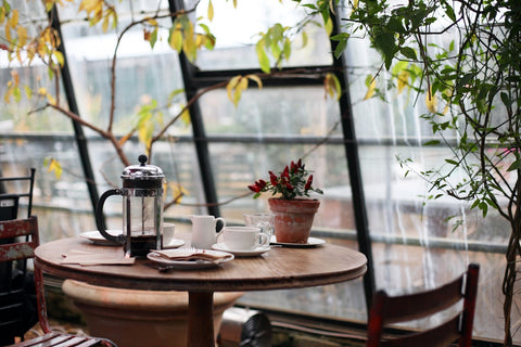 Intérieur chaleureux d'un café avec lumières douces, gens attablés et ambiance culturelle